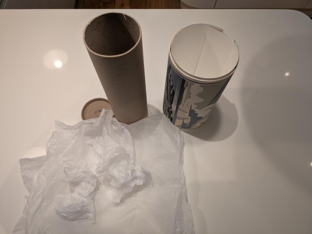 A RetroRoam print arriving rolled in tissue paper inside a rigid shipping tube