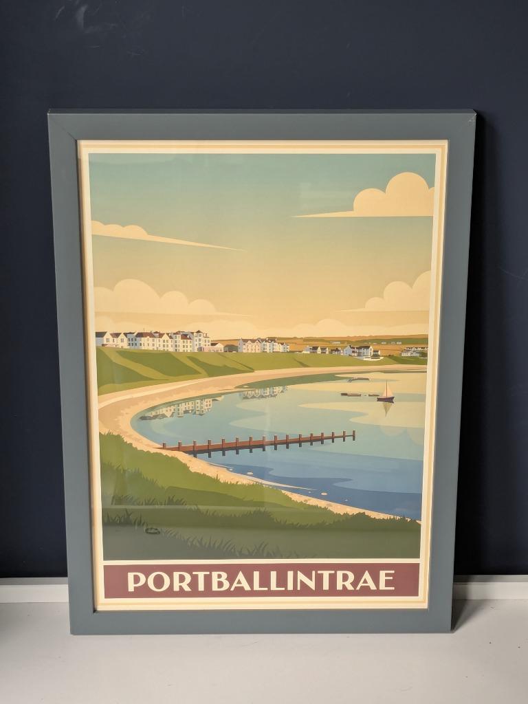 A RetroRoam print of Portballintrae in a classic grey frame against a deep blue wall